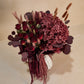 Bouquet of dark red and purple flowers on a light background